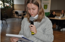 Dziewczynka czytająca z kartki do mikrofonu 