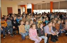Dzieci siedzące na ławkach.
