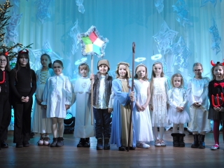 Dzieci przebrane za kolędników śpiewają na scenie 