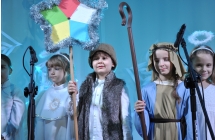Dzieci przebrane za kolędników stojący na scenie 