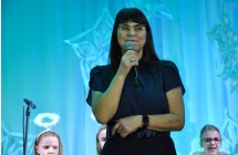 Kobieta na scenie mówiąca do mikrofonu 
