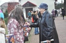 Kobieta wrzucająca pieniądze do puszek kwestujących osób 