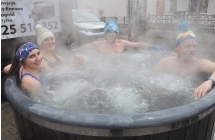 Dwie kobiety i dwoje mężczyzn siedzących w jacuzzi zewnętrznym 