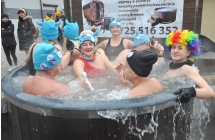 Kilka uśmiechniętych osób w zewnętrznym jacuzzi 