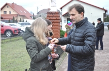 Mężczyzna wrzucający do puszki WOŚP pieniądze. 