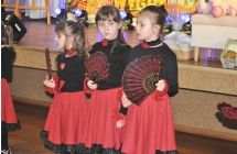 Trzy dziewczynki z grupy tanecznej. Ubrane w jednakowe stroje. Trzymają w rękach wachlarze 
