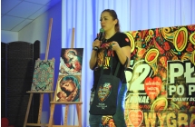 Kobieta na scenie przedstawia licytowany przedmiot 