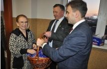 Dwoje mężczyzn częstujących kobietę słodkim upominkiem 