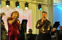 Kobieta i mężczyzna wykonujący utwór wokalny - śpiewają na scenie Centrum Kultury w Malanowie