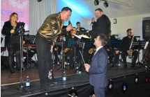 Mężczyzna na scenie rozmawia z drugim mężczyzną, który stoi pod sceną. 