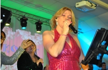 Charyzmatyczna wokalistka śpiewająca na scenie do mikrofonu 