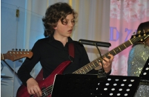 Młody mężczyzna skupiony na grze na gitarze basowej 