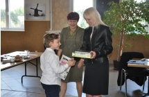 Kobieta wręczająca chłopczykowi nagrodę po konkursie recytatorskim w Centrum Kultury i Bibliotece Publiczne w Malanowie 