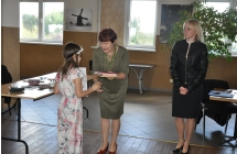 Kobieta wręcza dziewczynce dyplom/nagrodę 