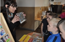 Kobieta pokazująca dzieciom kolekcje kapsli 