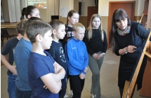 Kobieta prezentująca dzieciom kolekcję na sztalugach 