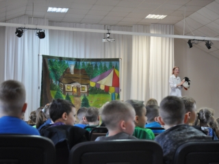 Dzieci siedza tyłem do patartu, w tle scena z aktorką