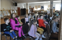 Widownia - grupa dzieci siedzi na krzesełkach wraz z opiekunką