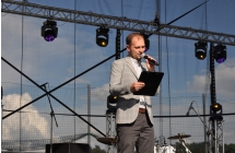 Konferansjer mówiący do mikrofonu ze sceny 
