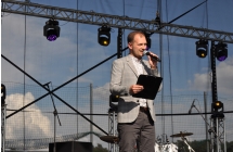 Mężczyzna mówiący do mikrofonu ze sceny 