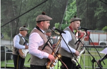 Troje mężczyzn z zespołu ludowego na scenie 