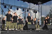 Kilkanaścioro jednakowo ubranych dzieci podczas występu tanecznego 