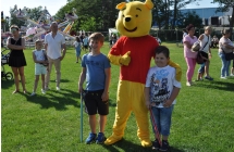 Osoba w stroju misia puchatka wraz z dziećmi 