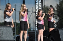 Czteroosobowy dziewczęcy zespół wokalny śpiewający na scenie 