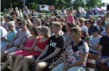 Publiczność imprezy siedząca na ławkach pod sceną 