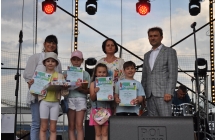 Dwie kobiety, mężczyzna i czworo nagrodzonych dzieci na scenie 