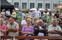 Publiczność siedząca na ławkach podczas występów artystycznych 