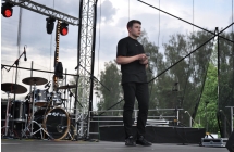 Młody wokalista wykonujący utwór wokalny na scenie 