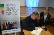 Mężczyzna dający autograf dziewczynce 