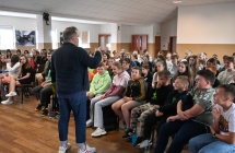 Uczniowie słuchający mężczyzny na spotkaniu autorskim 