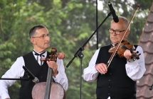 Dwoje muzyków na scenie. Grają na skrzypcach oraz basach kaliskich 