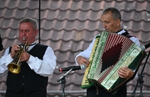 Dwóch muzyków ludowych na scenie. Jeden gra na trąbce, drugi na akordeonie 