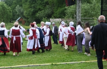 Członkowie zespołów ludowych tańczą pod sceną