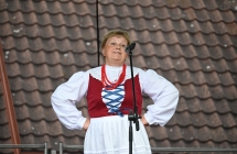 Kobieta śpiewająca na scenie do mikrofonu, Ubrana w ludowy strój 