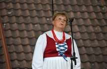 Kobieta śpiewająca do mikrofonu w ludowym stroju