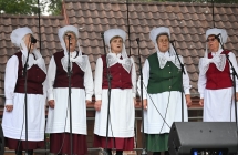 Pięć kobiet w ludowych strojach śpiewające ludowe pieśni 