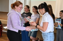 Kobieta wręczająca nagrodę i dyplom uczniom 