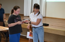 Kobieta wręczająca dyplom dziewczynce 