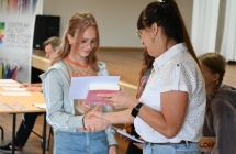 Kobieta wręczająca dyplom i nagrodę dziewczynce 