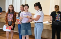 Kobieta wręczająca dziewczynce dyplom 