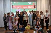 Kilkudziesięciu uczestników gry terenowej oraz spotkania autorskiego stojący na scenie 