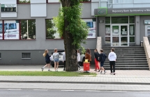 Grupa dzieci podczas szukania podpowiedzi, która umiejscowiona jest w drzewie 