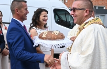 Dwoje mężczyzn i kobieta. Trzymają chleb dożynkowy 