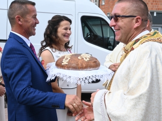 Dwoje mężczyzn i kobieta. Trzymają chleb dożynkowy 