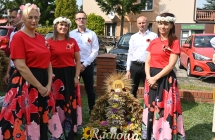 Dwoje mężczyzn i trzy kobiety przy wieńcu dożynkowym 