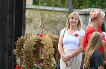 Elegancko ubrana kobieta przy wieńcu dożynkowym